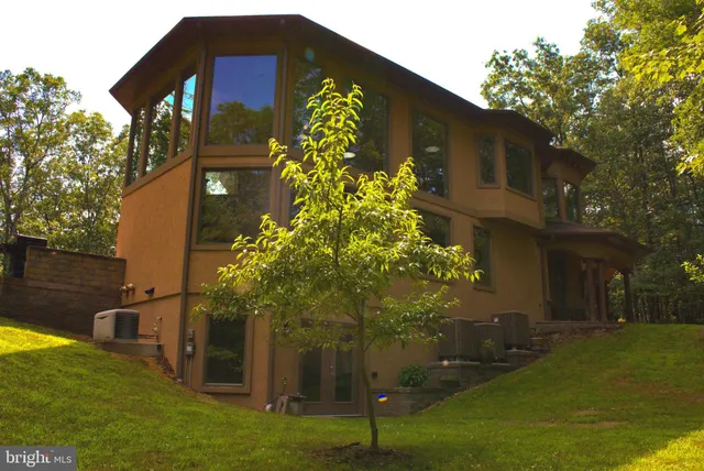 an aerial view of a house with swimming pool and porch