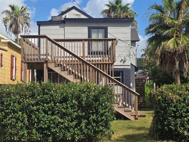 a balcony with tall trees in front of it
