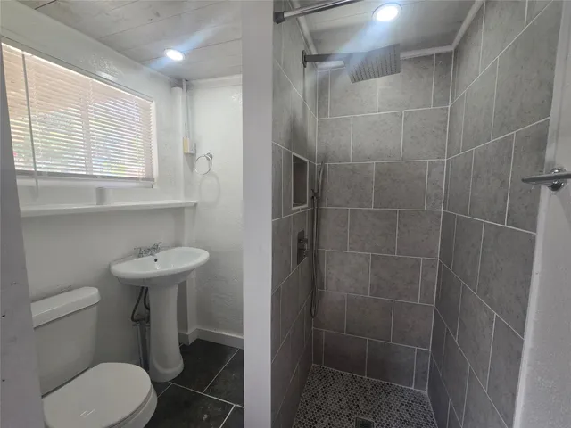 a bathroom with a sink toilet and a mirror