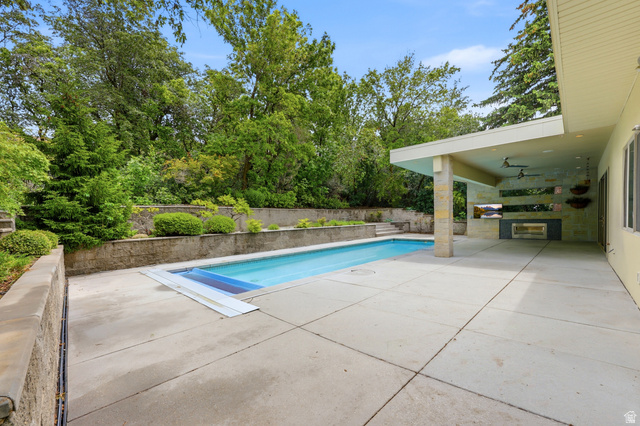 1389 Millbrook Way Bountiful, UT 84010 - Photo 68 of 74 Expansive concrete patio with an integrated swimming pool and stone retaining walls