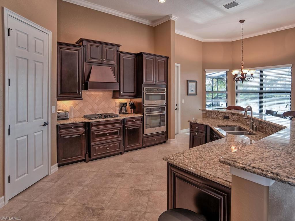 9634 Firenze Circle Naples, FL 34113 - Photo 6 of 35 a kitchen with stainless steel appliances granite countertop a stove refrigerator and a sink