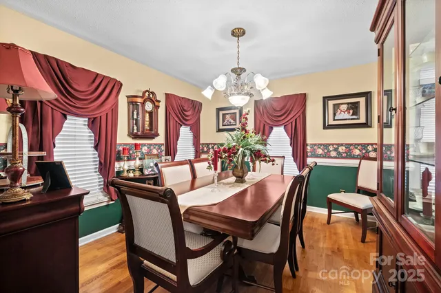 a dining room with furniture a chandelier and window