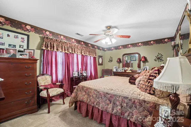 a bedroom with a bed a chandelier and a dresser