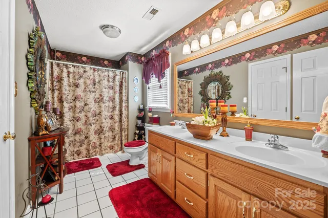 a bathroom with a double vanity sink mirror and shower