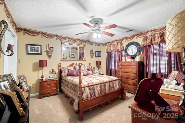 a bedroom with a bed mirror and a window