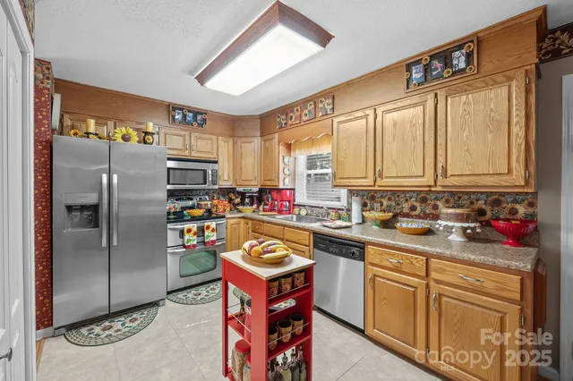 a kitchen with stainless steel appliances granite countertop a sink a stove and refrigerator