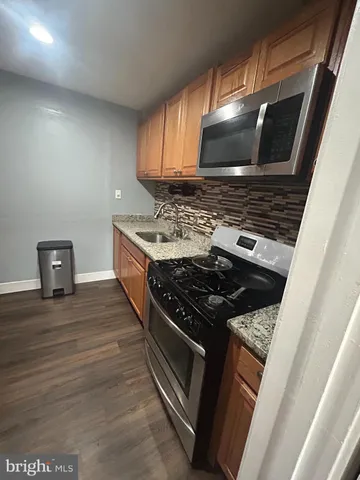 a kitchen with granite countertop a stove and a sink