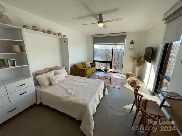 a living room with furniture a large window and a flat screen tv