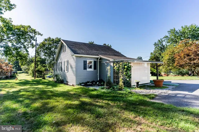 a view of a house with a big yard and a large tree