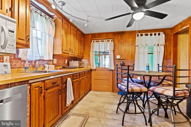 a kitchen with stainless steel appliances granite countertop table chairs sink and large window
