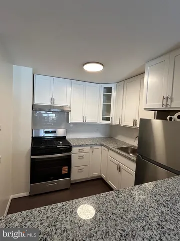 a kitchen with a stove a sink and a refrigerator