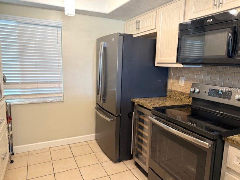 108 Nina Way, Unit 3 Oldsmar, FL 34677 - Photo 11 of 25 a kitchen with stainless steel appliances granite countertop a refrigerator and a stove top oven