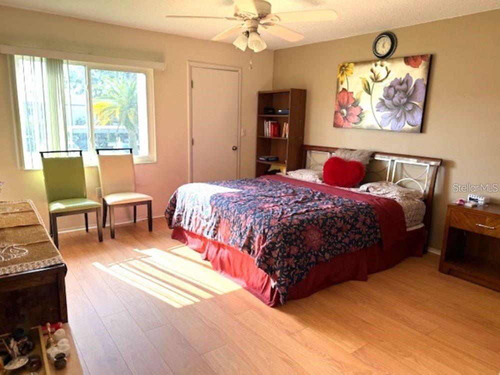 108 Nina Way, Unit 3 Oldsmar, FL 34677 - Photo 12 of 25 a bedroom with a bed a chair and a chandelier