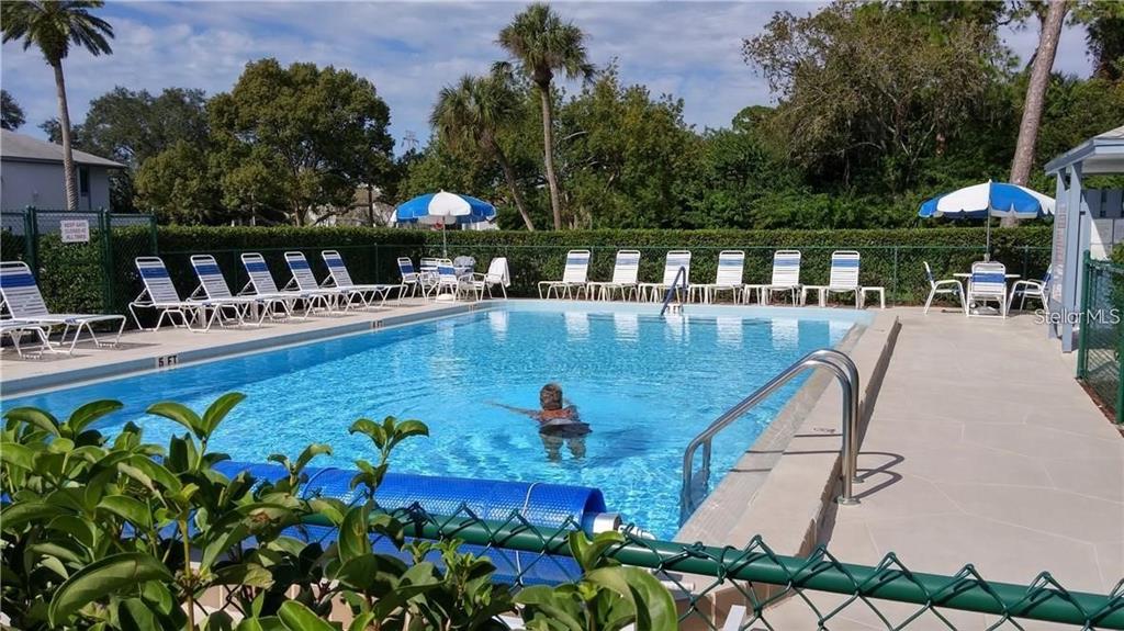 108 Nina Way, Unit 3 Oldsmar, FL 34677 - Photo 2 of 25 a view of a swimming pool with a table and chairs under an umbrella