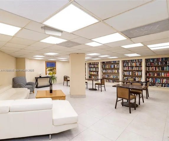 a living room with furniture a ceiling fan and a large window