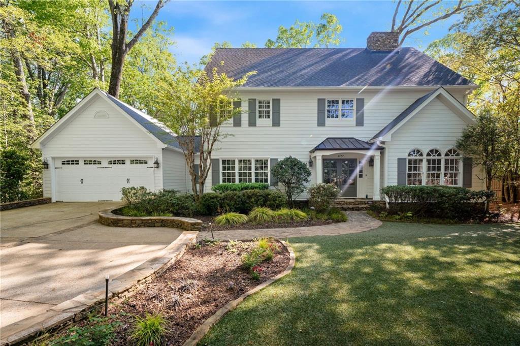 a front view of a house with yard and green space