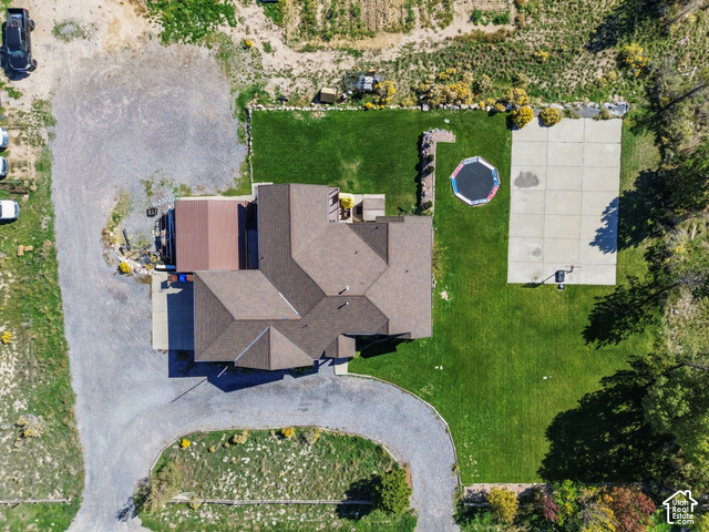 9044 North Cedar Pass Road Eagle Mountain, UT 84005 - Photo 60 of 63 Expansive property featuring a multi-gabled roofline, concrete sports court, established green lawn, and gravel driveways