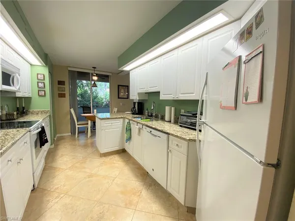 a large white kitchen with a large window