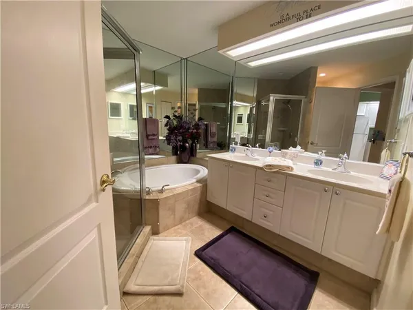 a bathroom with a double vanity sink a toilet a mirror and shower
