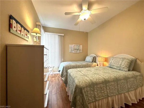 a bedroom with two beds and a chandelier