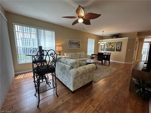 a living room with furniture dining area and a window