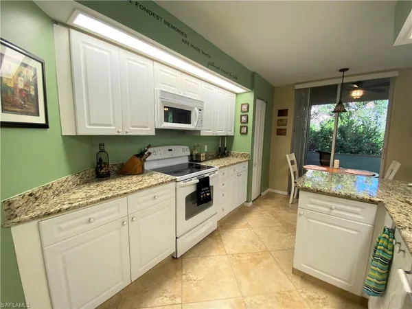 a kitchen with granite countertop a sink stainless steel appliances and cabinets