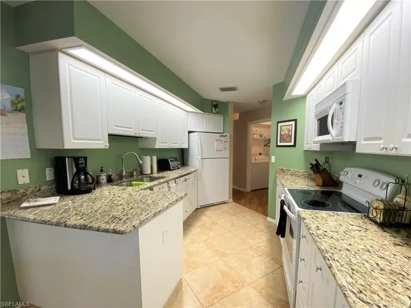 a kitchen with sink refrigerator and stove