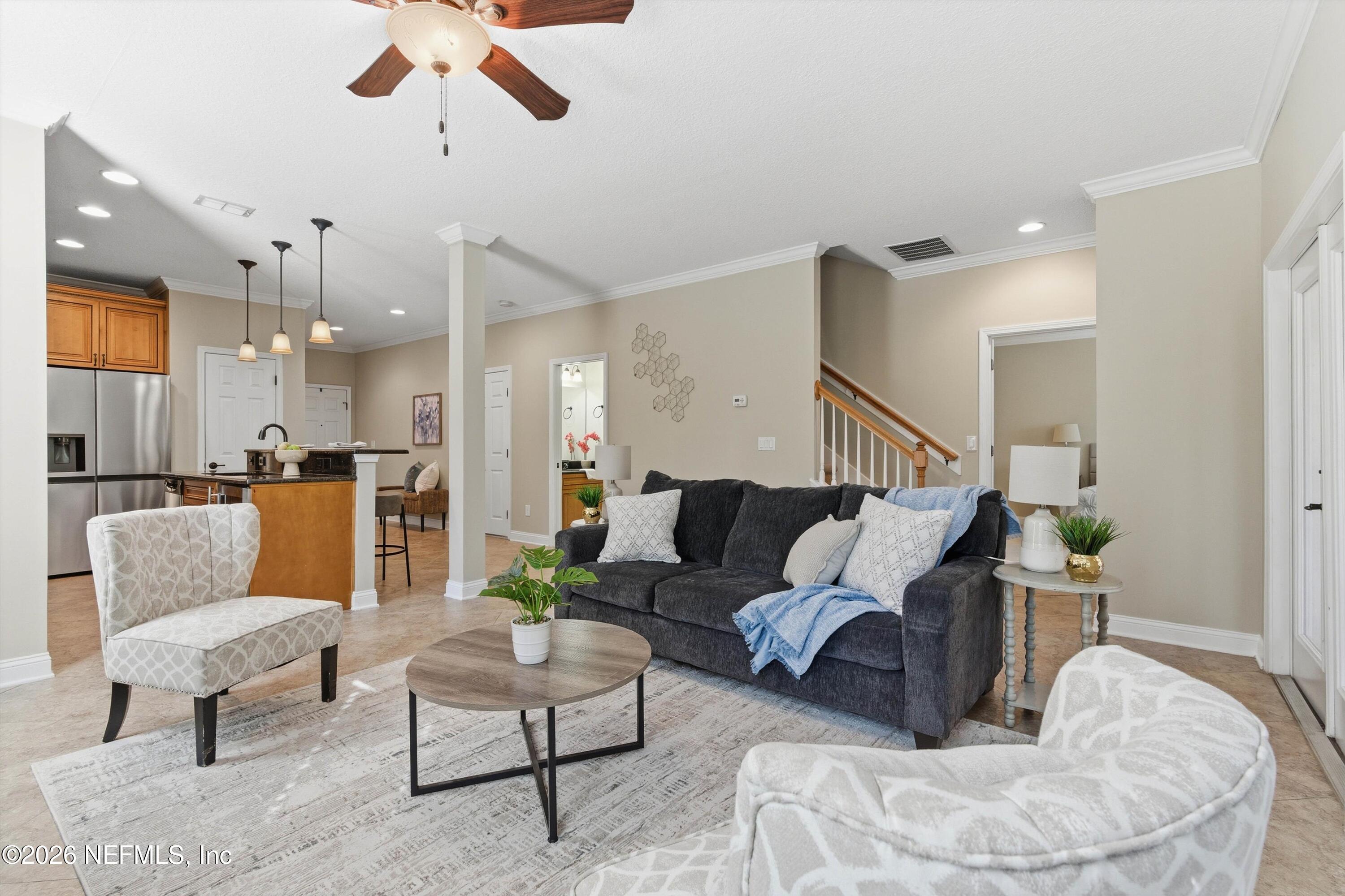 1733 Sanctuary Way Fleming Island, FL 32003 - Photo 11 of 39 a living room with furniture kitchen view and a chandelier
