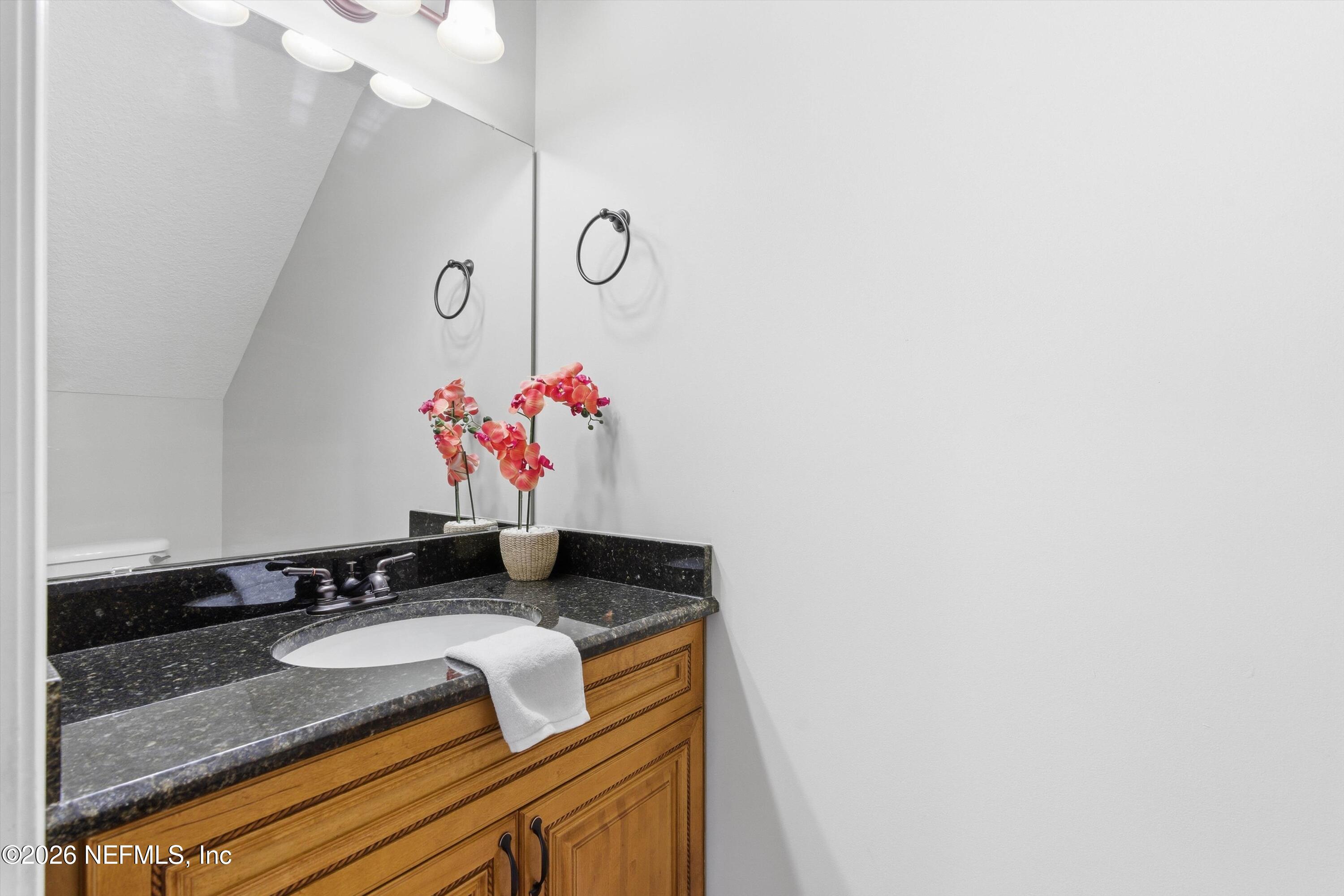 1733 Sanctuary Way Fleming Island, FL 32003 - Photo 13 of 39 a bathroom with a granite countertop sink and a mirror
