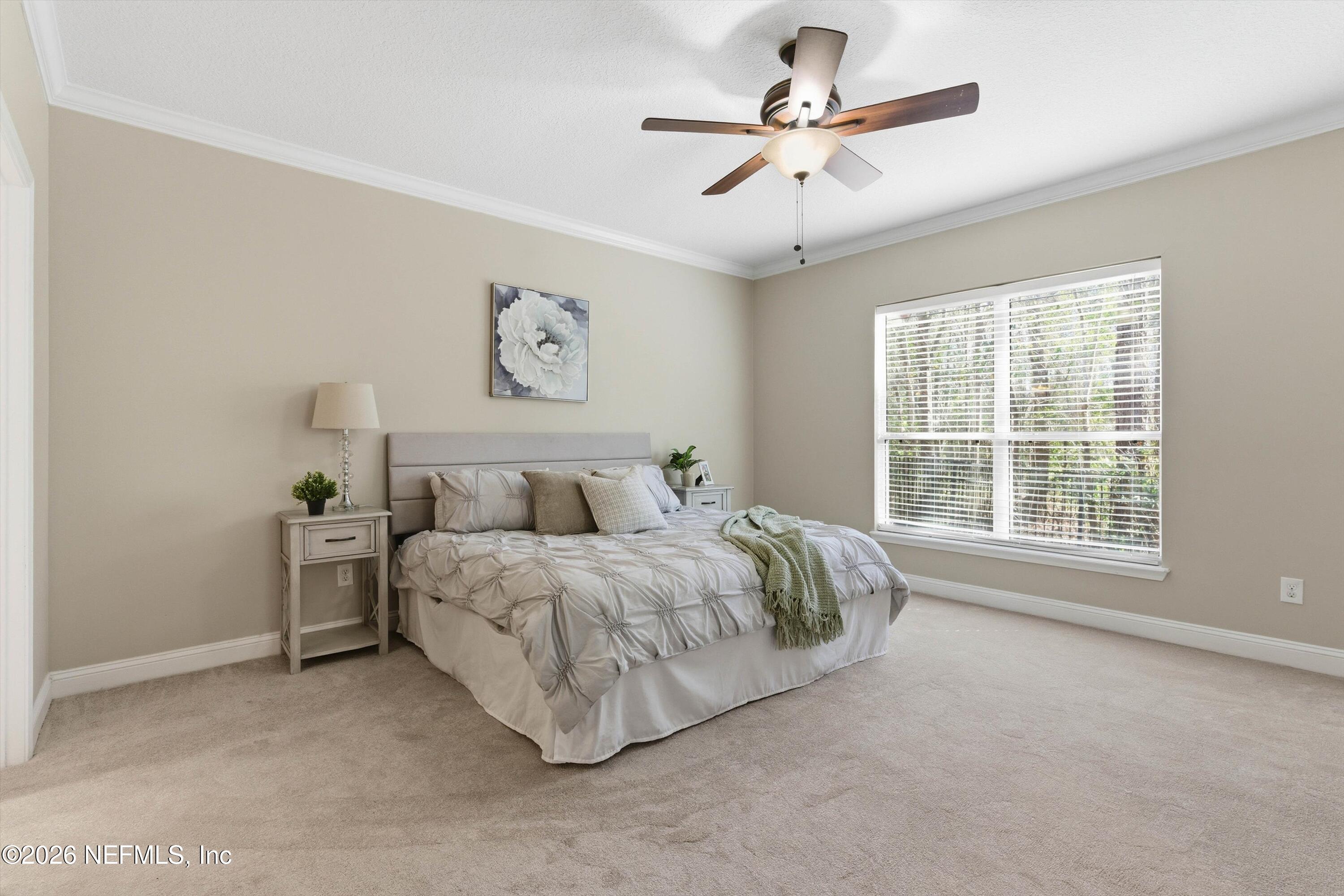 1733 Sanctuary Way Fleming Island, FL 32003 - Photo 14 of 39 a spacious bedroom with a bed and a ceiling fan