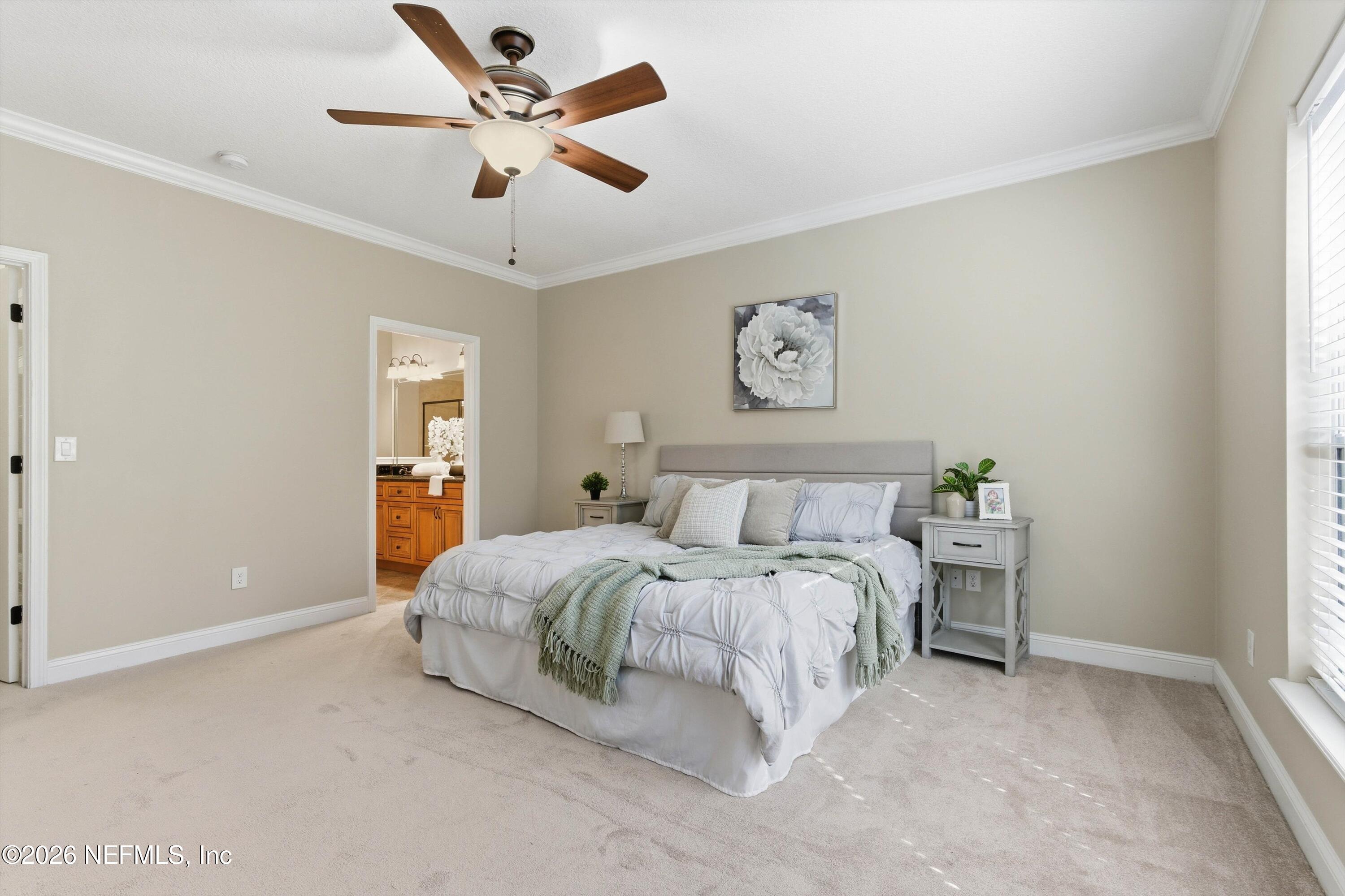 1733 Sanctuary Way Fleming Island, FL 32003 - Photo 15 of 39 a spacious bedroom with a bed and a chandelier