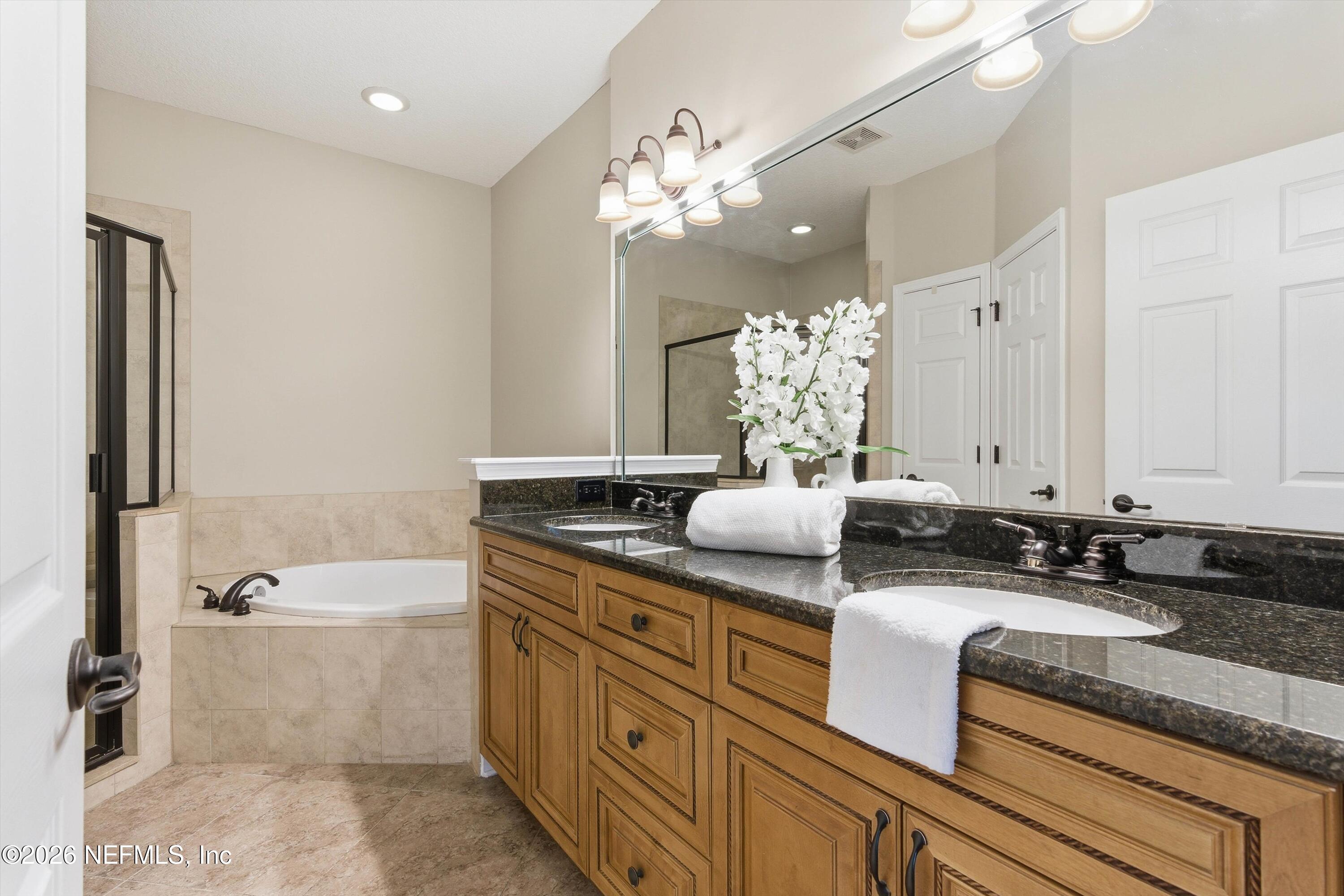 1733 Sanctuary Way Fleming Island, FL 32003 - Photo 18 of 39 a bathroom with a granite countertop sink and a mirror