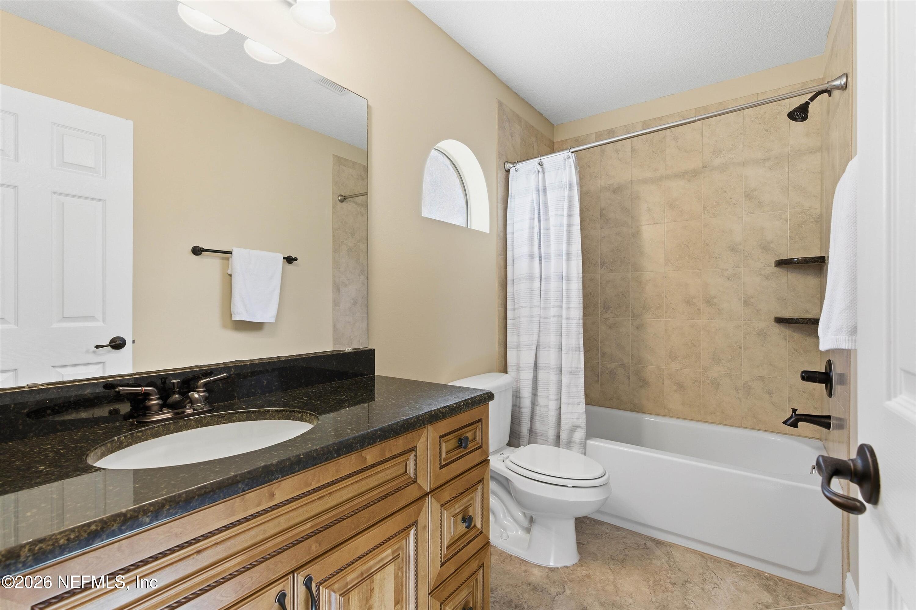 1733 Sanctuary Way Fleming Island, FL 32003 - Photo 25 of 39 a bathroom with a granite countertop sink toilet a mirror and shower
