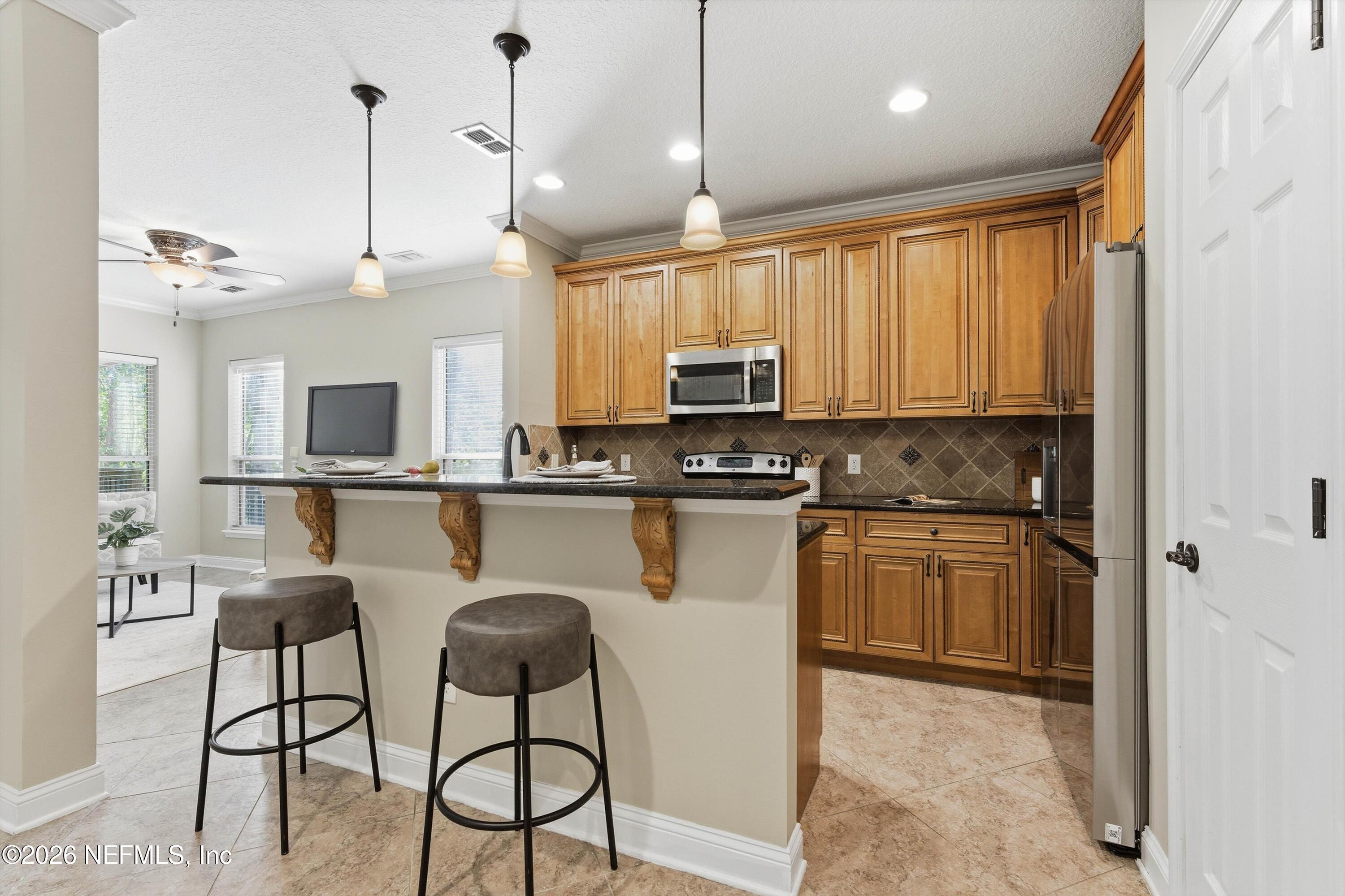 1733 Sanctuary Way Fleming Island, FL 32003 - Photo 5 of 39 a kitchen with stainless steel appliances granite countertop a stove a sink and a microwave
