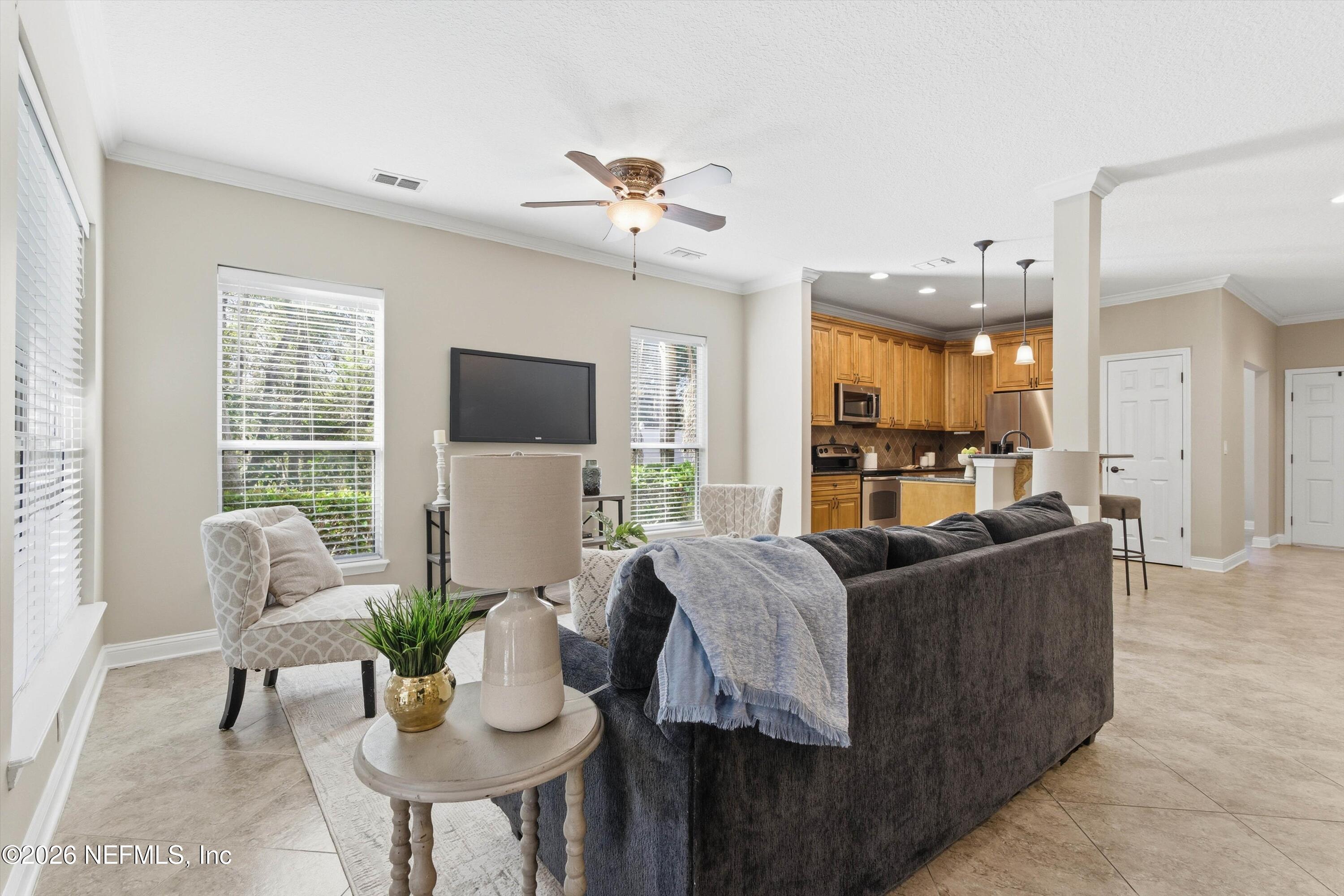 1733 Sanctuary Way Fleming Island, FL 32003 - Photo 10 of 39 a living room with furniture kitchen view and a large window