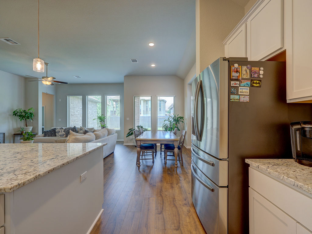 229 Heartleaf Road San Marcos, TX 78666 - Photo 14 of 40 A streamlined open-concept layout connects the kitchen, dining, and living areas for modern living.