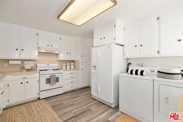 a kitchen with cabinets appliances and a wooden floor