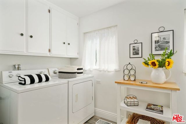 a kitchen with stainless steel appliances granite countertop a sink a stove and white cabinets