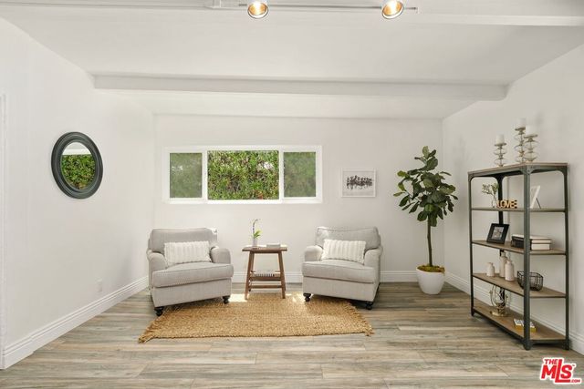 a living room with furniture a window and a potted plant