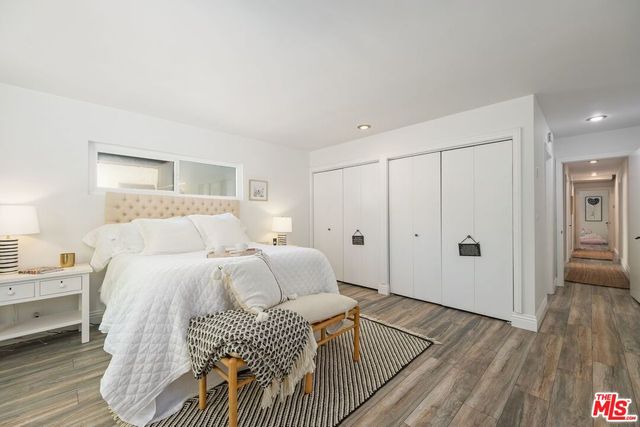 a spacious bedroom with a bed and wooden floor