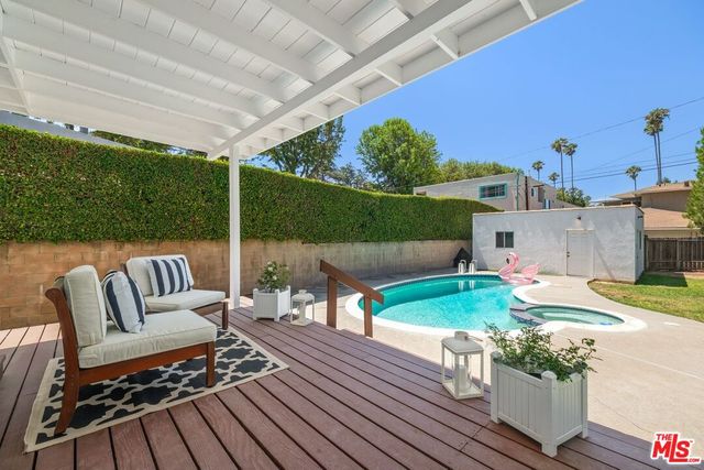 a view of a patio with table and chairs potted plants with wooden floor