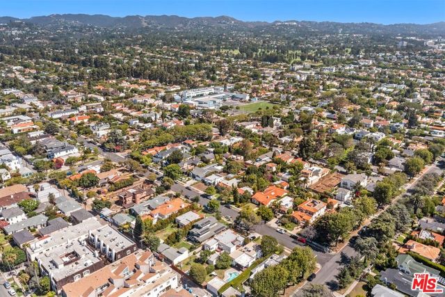 an aerial view of residential houses with outdoor space and trees