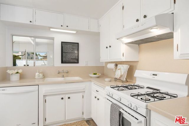 a kitchen with white cabinets and appliances