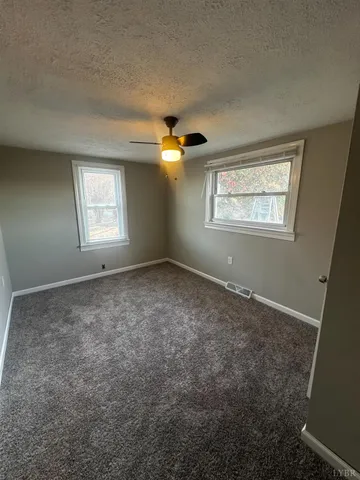 a view of a livingroom with a ceiling fan and window
