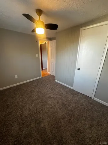 an empty room with a ceiling fan and a window