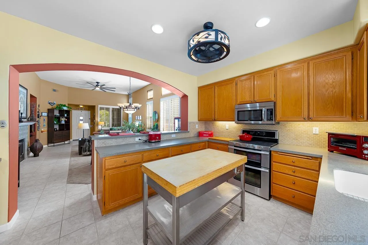 2460 Eagle Valley Drive Chula Vista, CA 91914 - Photo 11 of 35 a living room with stainless steel appliances furniture a flat screen tv and kitchen view