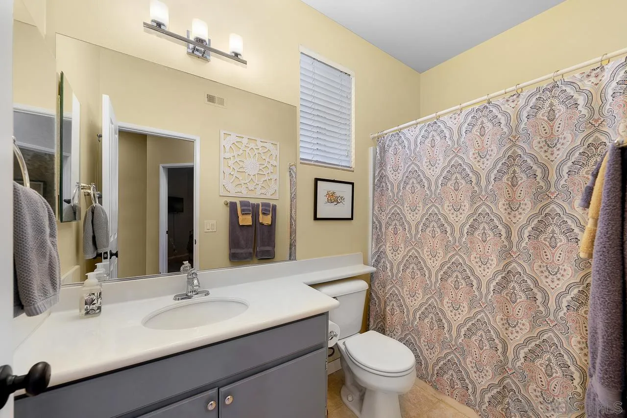 2460 Eagle Valley Drive Chula Vista, CA 91914 - Photo 24 of 35 a bathroom with a granite countertop sink a toilet and a mirror