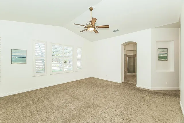 an empty room with a ceiling fan and a window