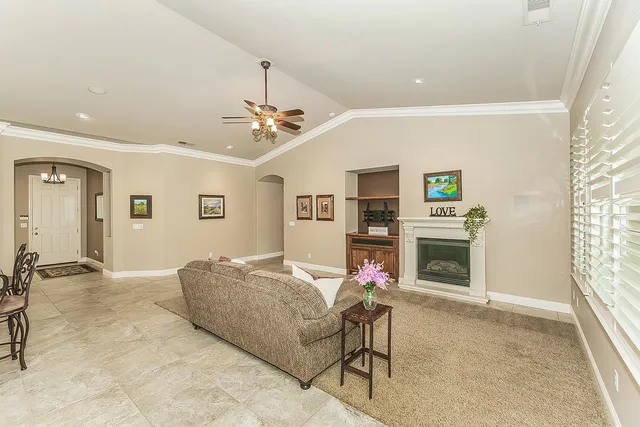 a living room with furniture a fireplace and a window