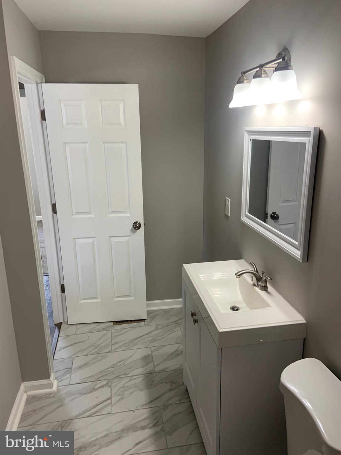 717 Fuselage Avenue Middle River, MD 21221 - Photo 14 of 31 a bathroom with a sink toilet and mirror